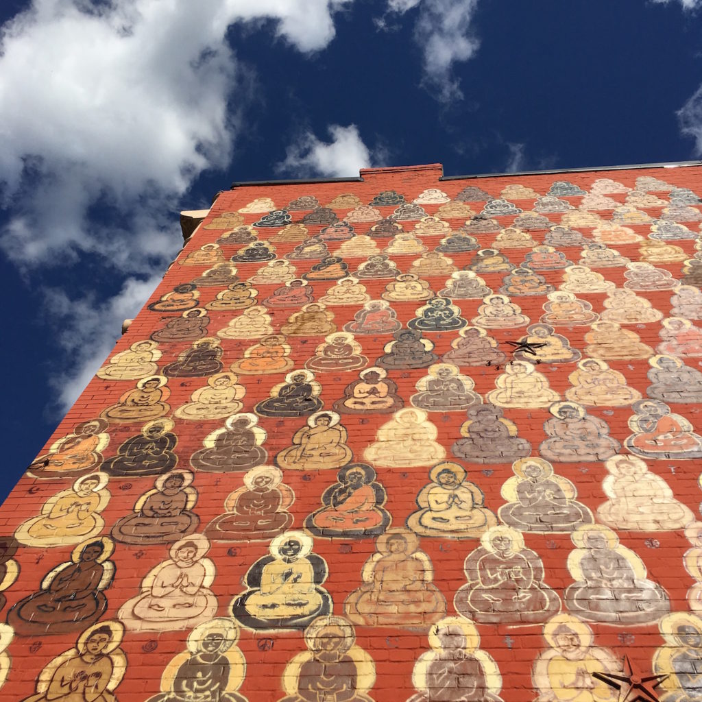 Buddhas Mural - View up the mural with the sky in the background